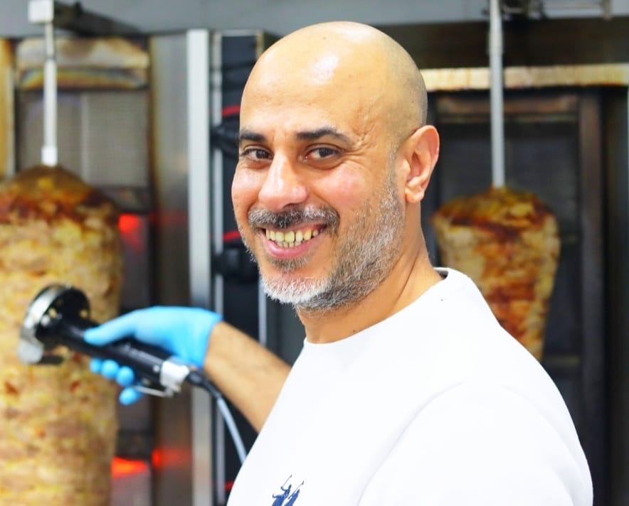 Il titolare davanti agli spiedi di kebab
